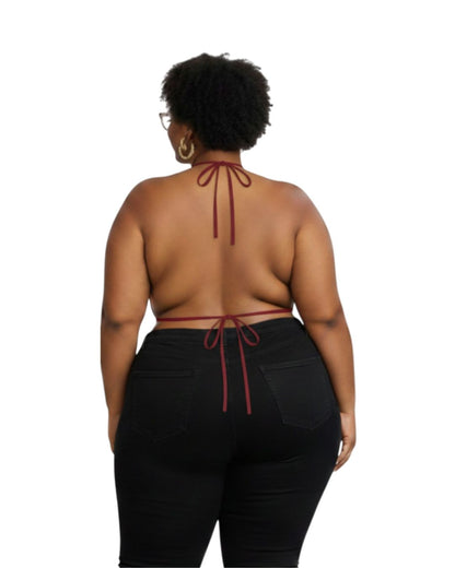 Person wearing a halter top with red straps and black pants on a white background